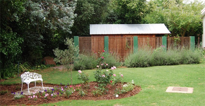 garden shed behind a screen wall